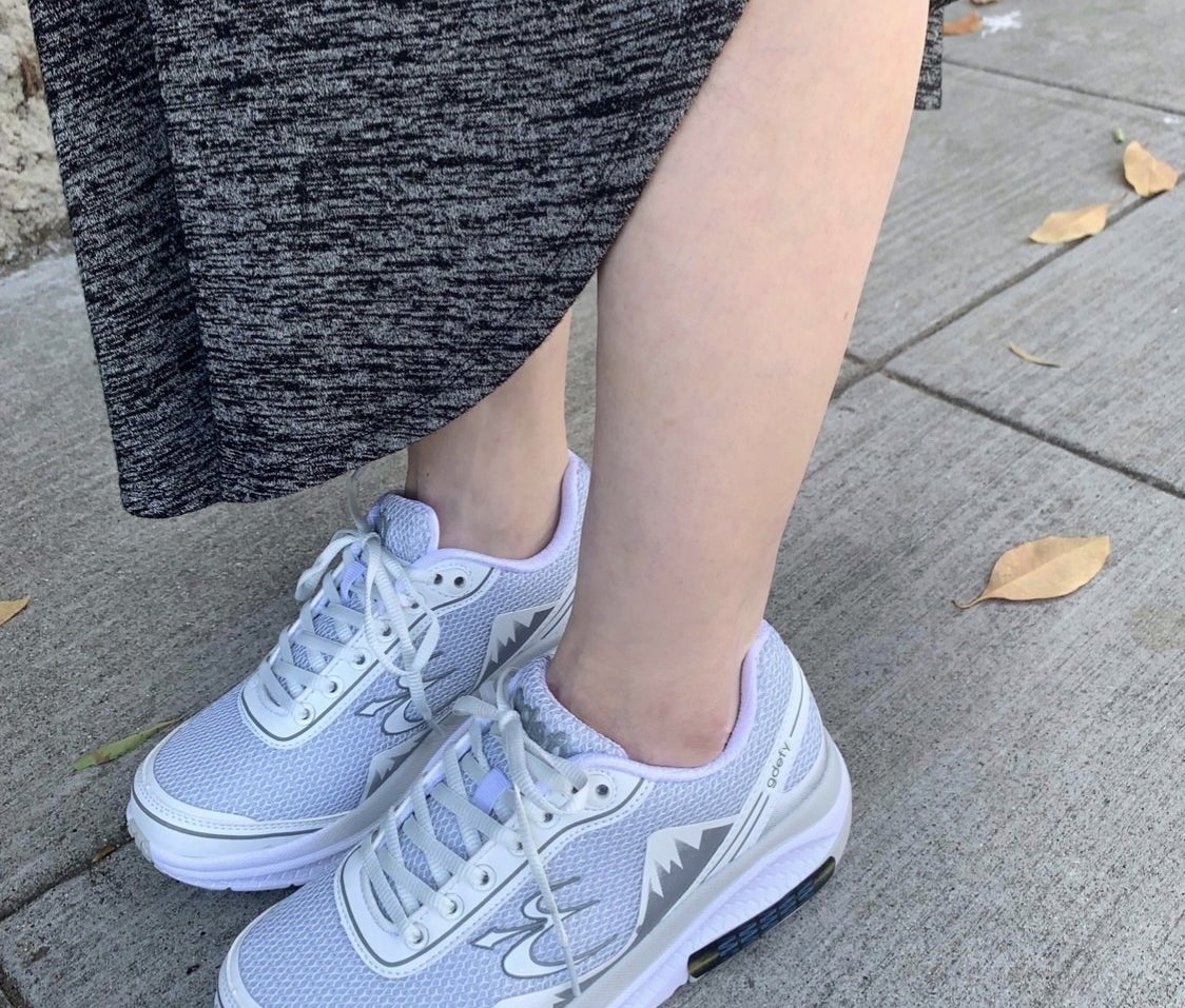 A reviewer wearing grey sneakers