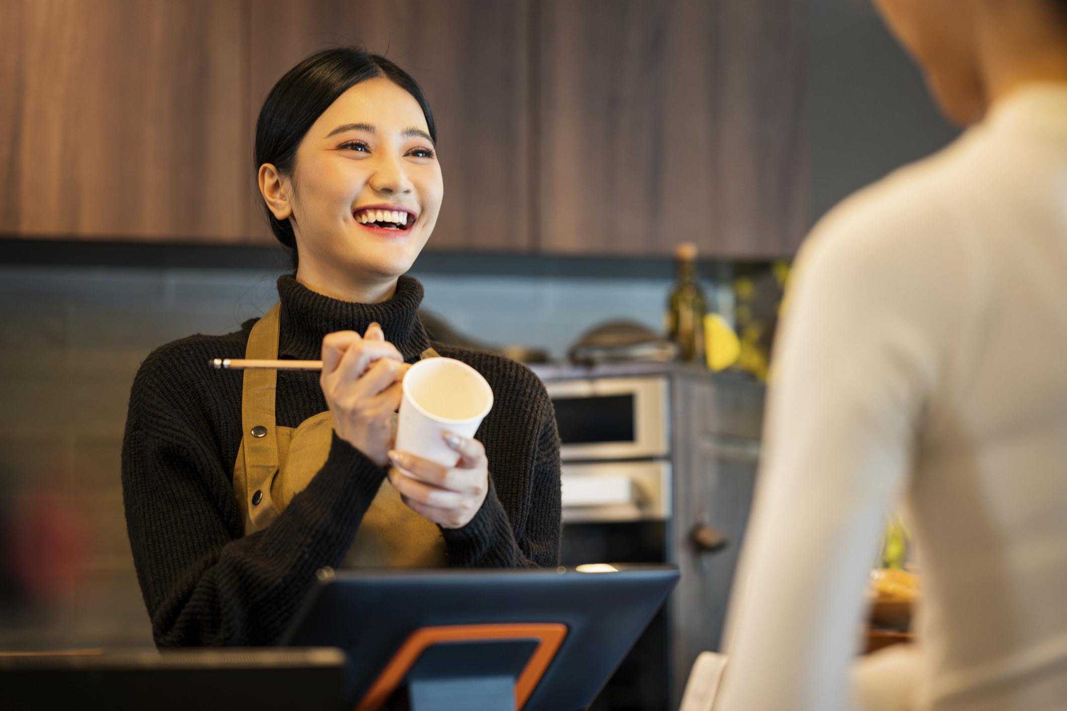 barista writing on a coffee cup