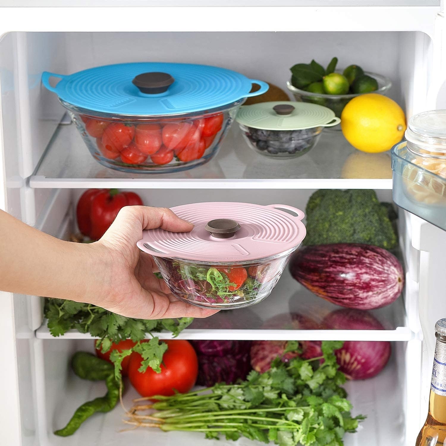 The silicone lids over different dishes in a fridge