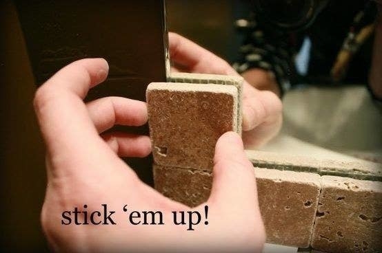 hand placing tiles on a mirror