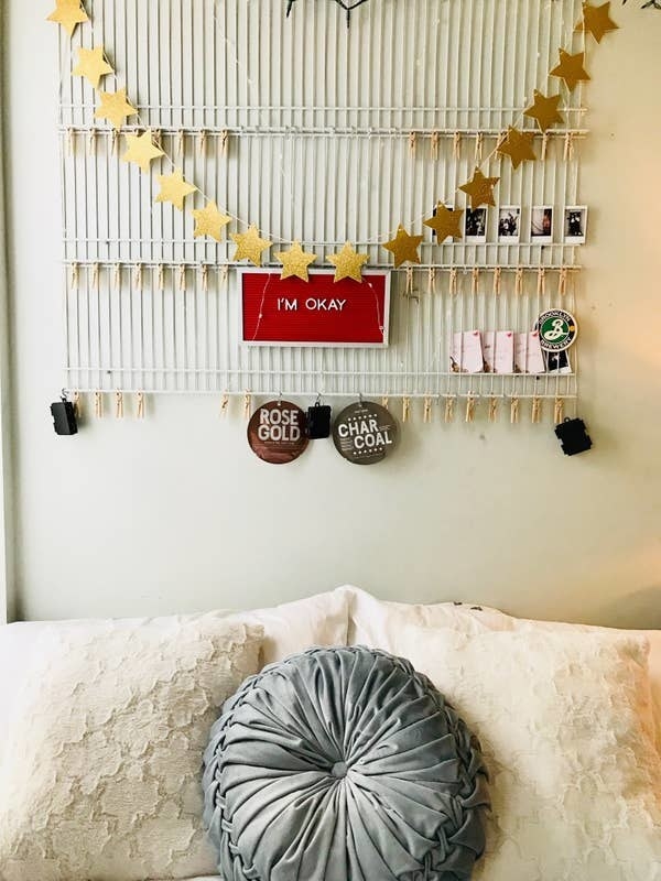 wire shelves on the wall holding photos