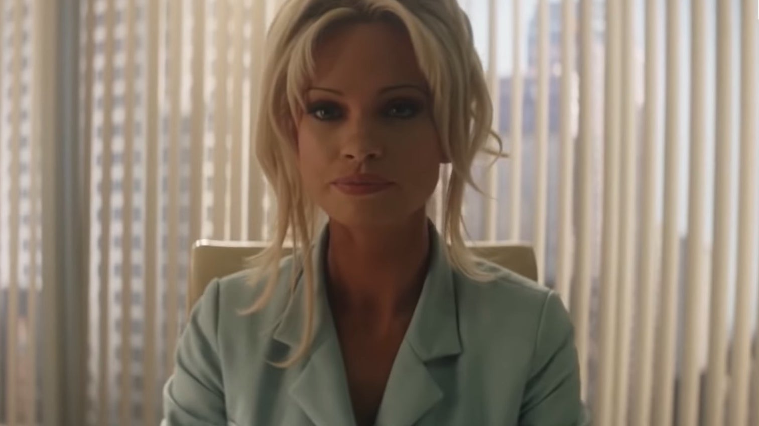 Pamela Anderson sitting in an office in &quot;Pam &amp;amp; Tommy&quot;