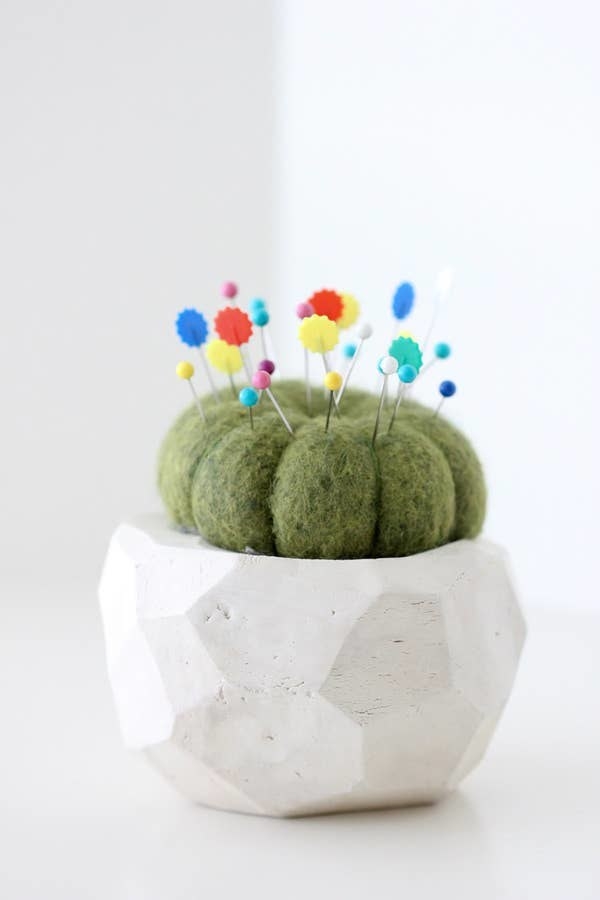wool cactus in a pot with pins sticking out of it