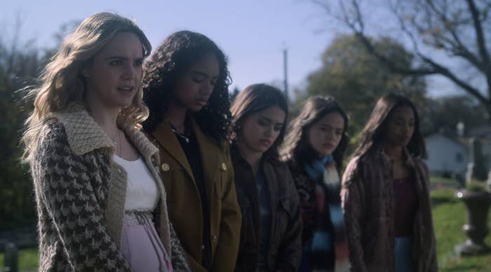 The Liars standing together outside and looking down