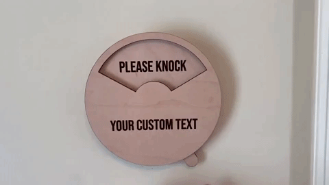a gif of someone rotating the sign from Please Knock, to In a Meeting, to Do Not Disturb.