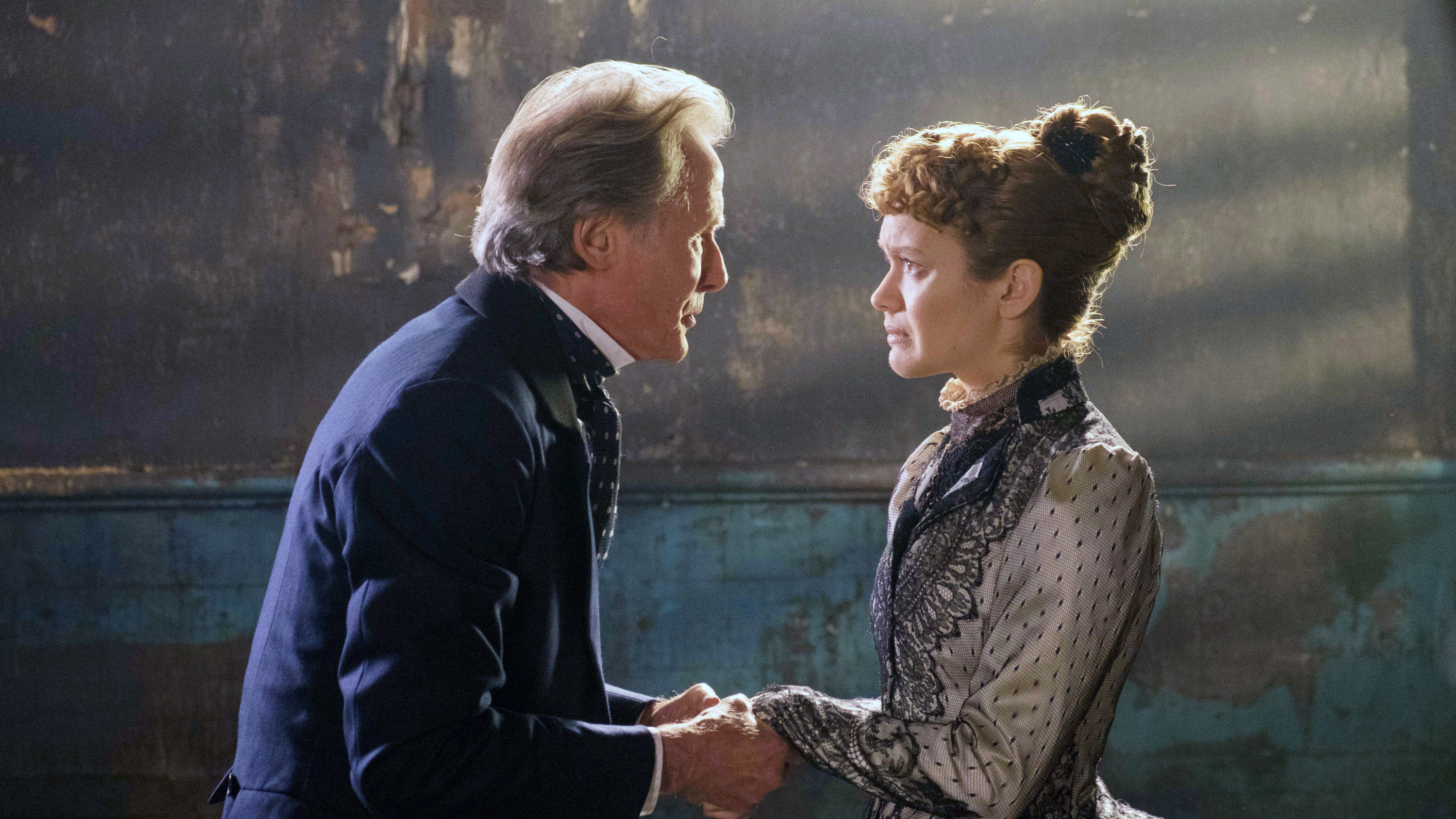 Bill Nighy and Olivia Cooke hold hands an look at one another