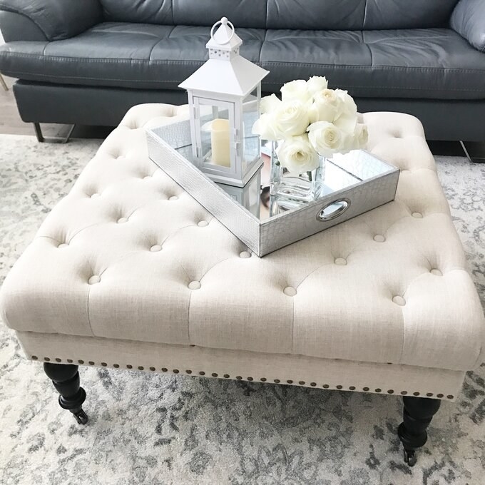 a reviewer photo of the crema ottoman with a silver tray on top