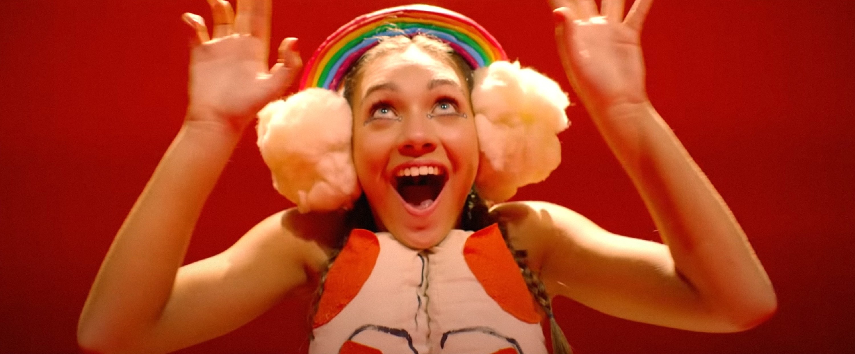 close up of Maddie wearing  rainbow earmuffs with clouds
