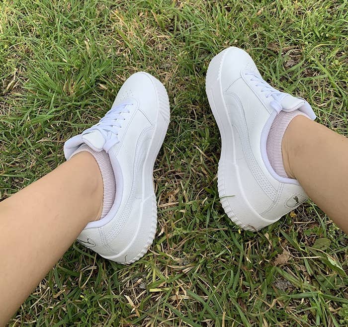 Reviewer wearing white sneakers