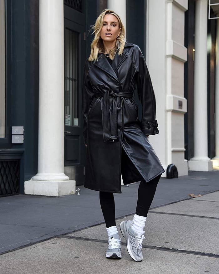 a person wearing the trench coat with sneakers