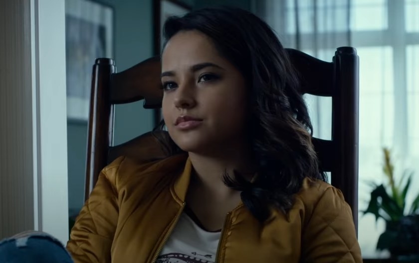 Becky G as Trini Kwan sitting down at a dinner table