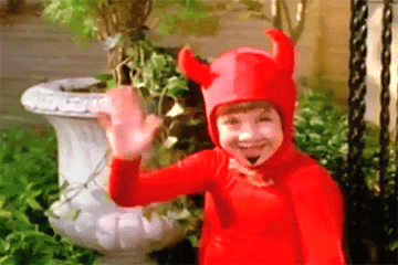 A child in a devil costume waving