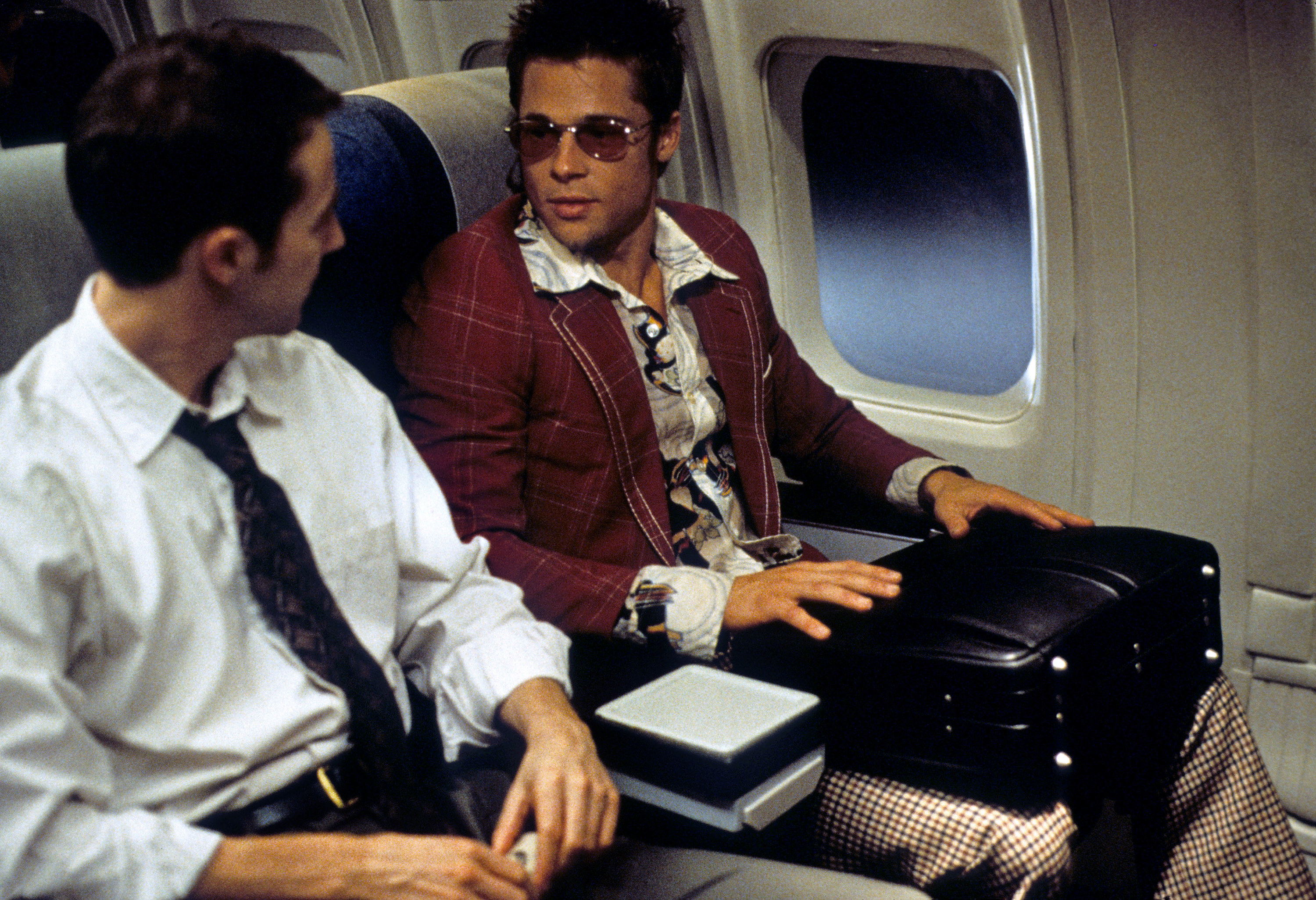 Edward Norton and Brad Pitt sitting on a plane.