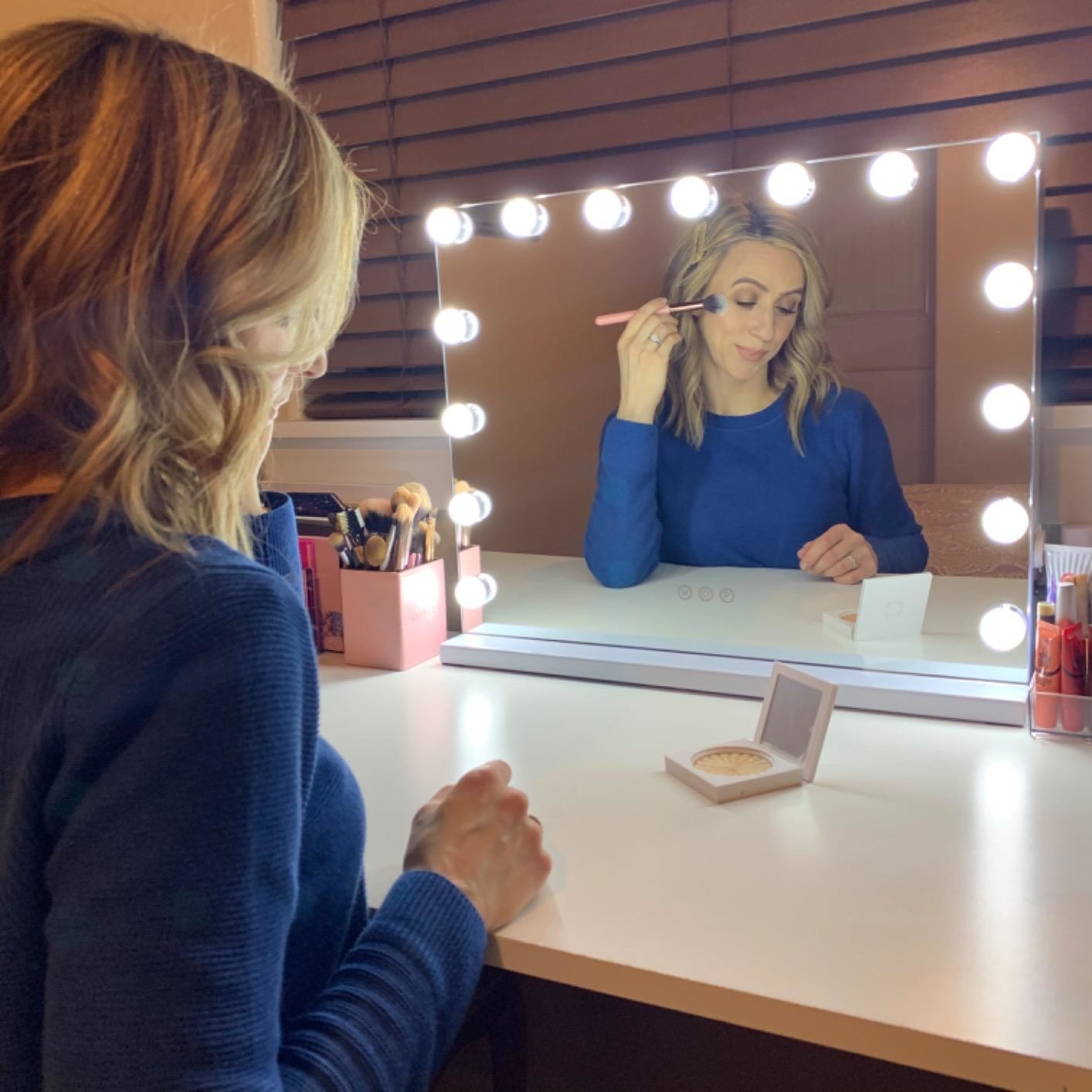 reviewer using the vanity mirror