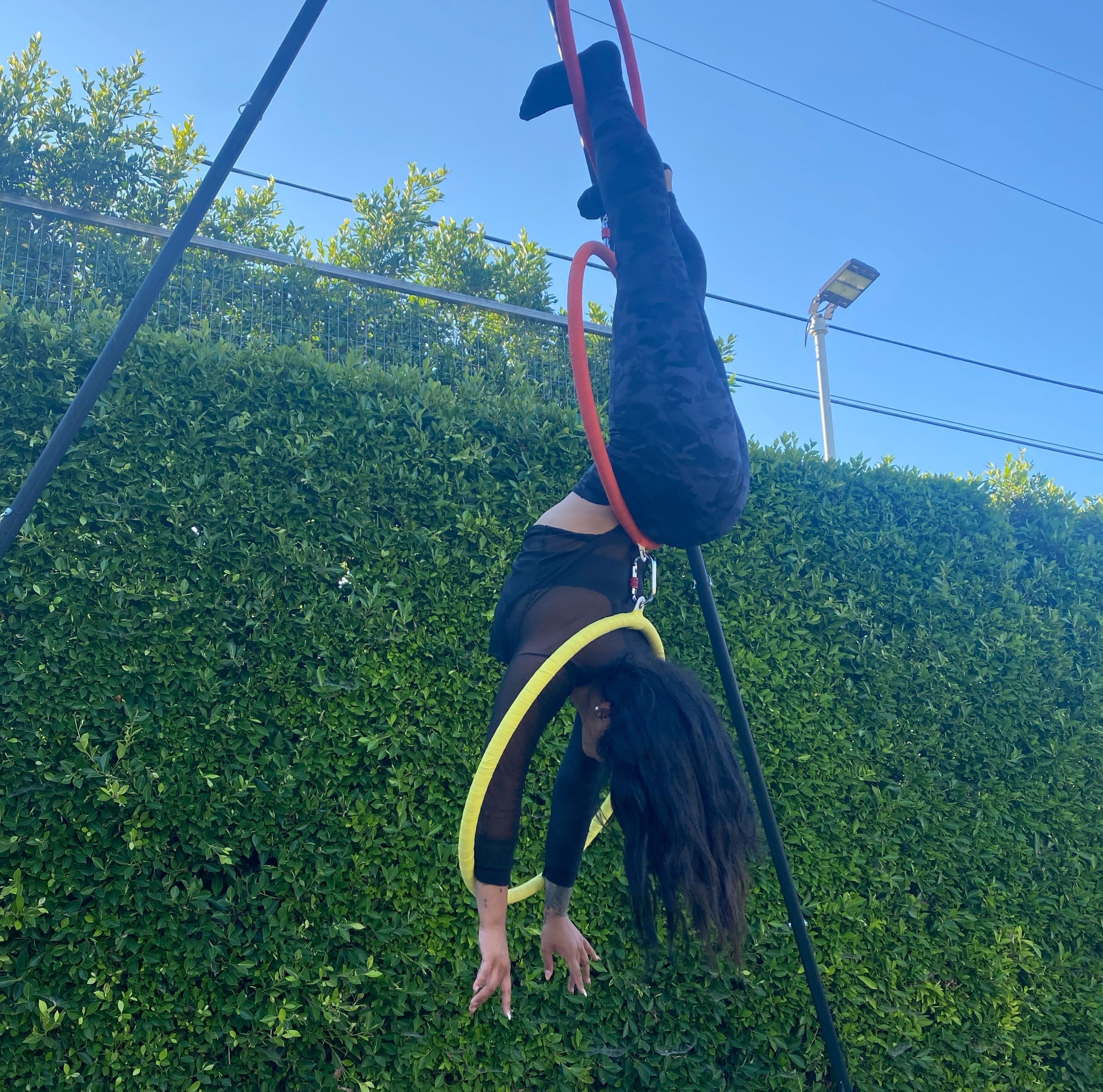 a reviewer wearing the black camo leggings while doing aerial acrobatics