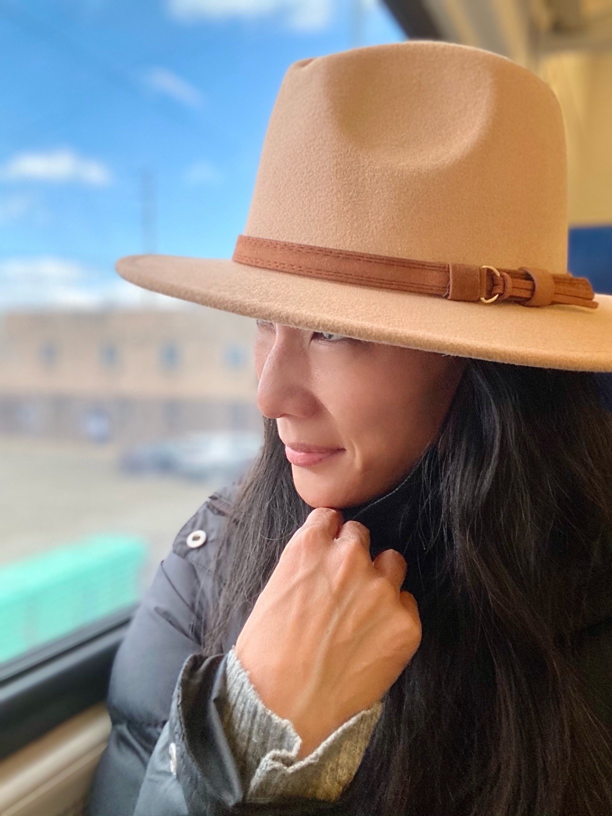 a reviewer wearing the tan hat while looking out the window