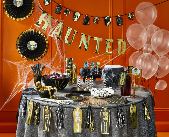 halloween party table with black and orange decorations