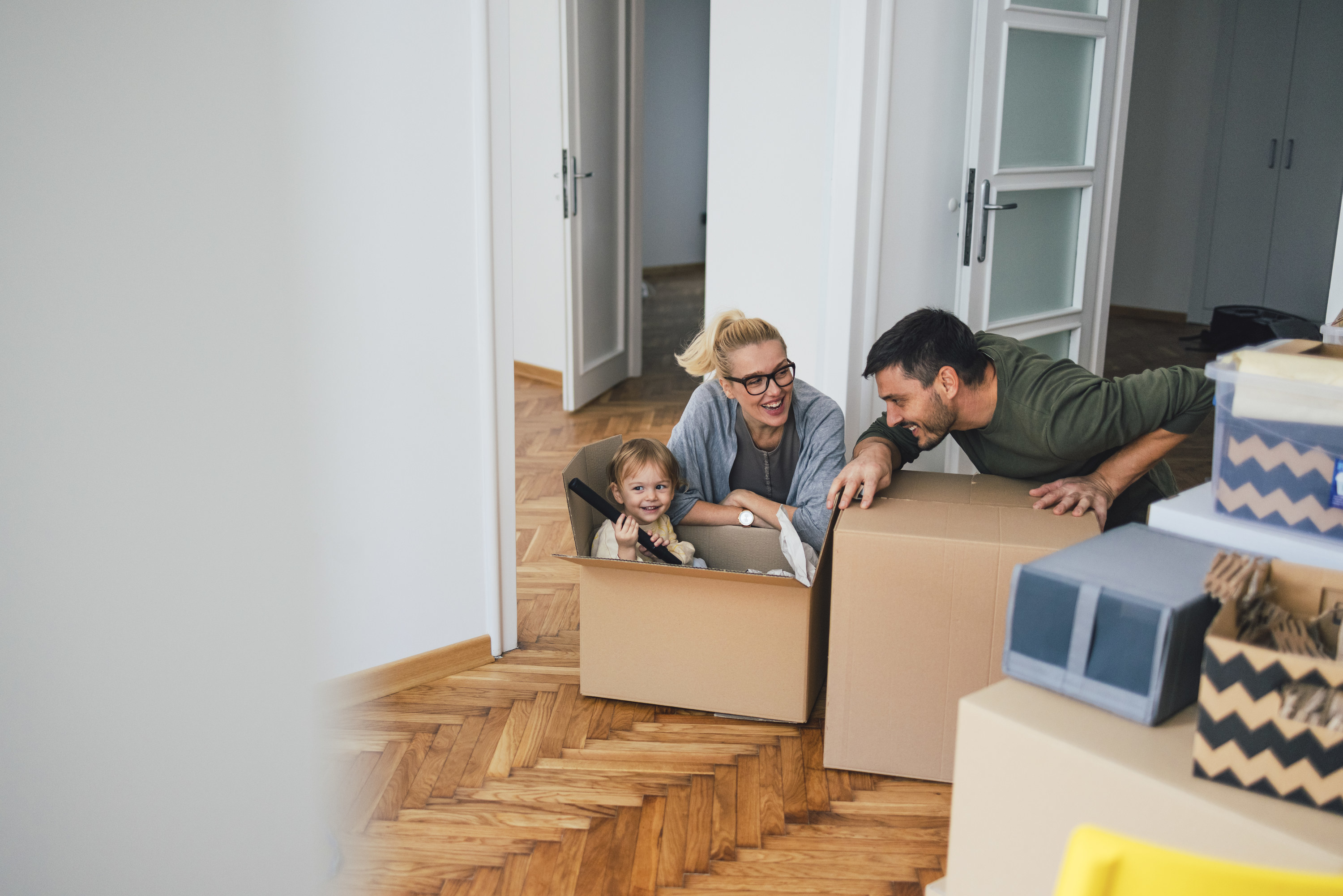 Family of three is moving in or out of a room in an apartment or a house