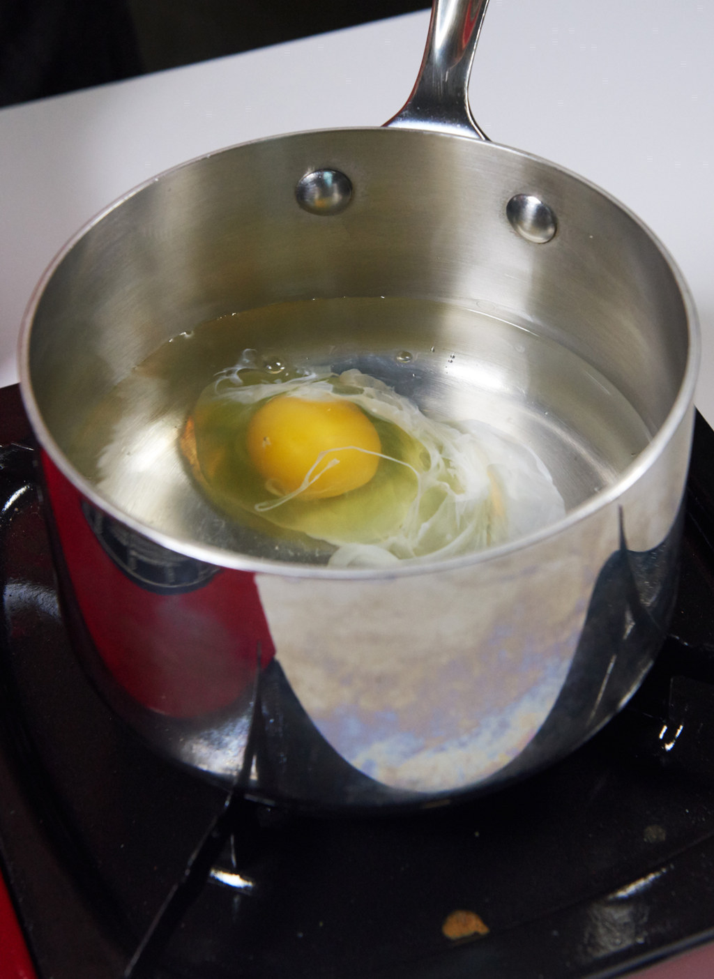 An egg being poached in a pot