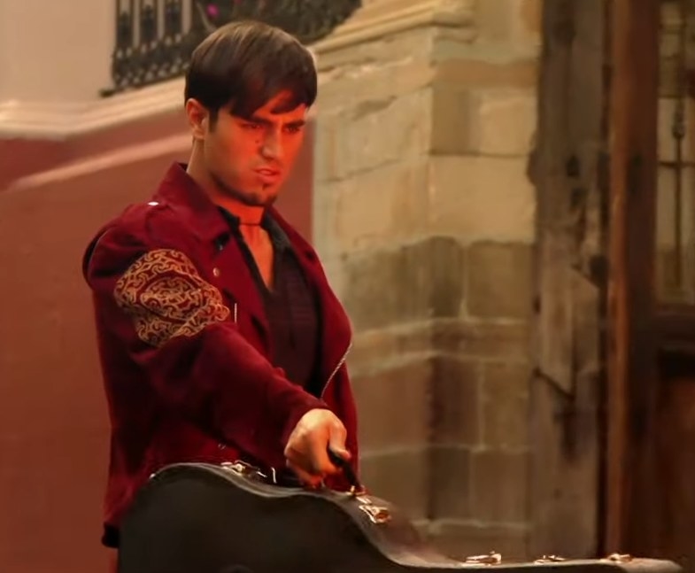 Enrique Iglesias as Lorenzo shooting a flamethrower from his guitar case