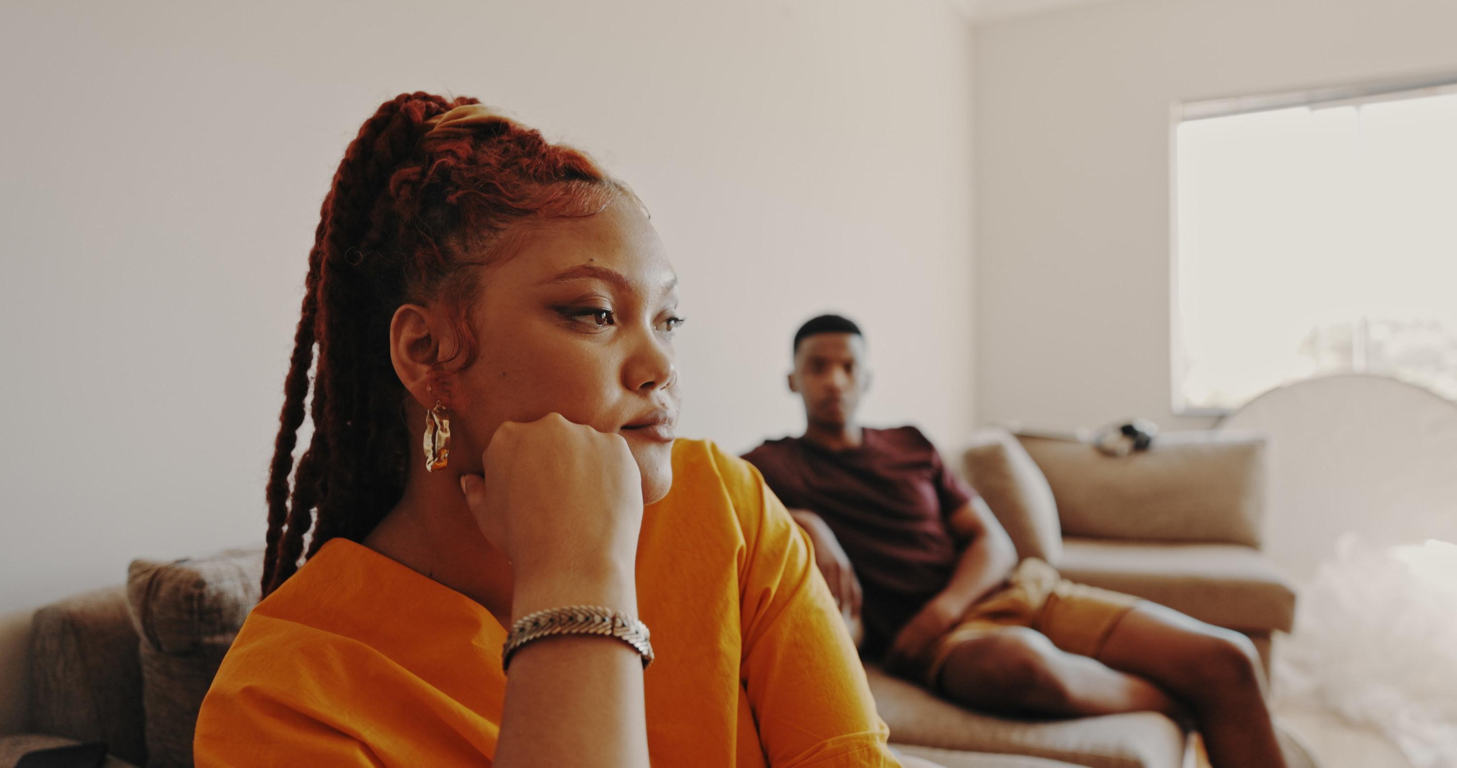 pensive woman with her partner in the background