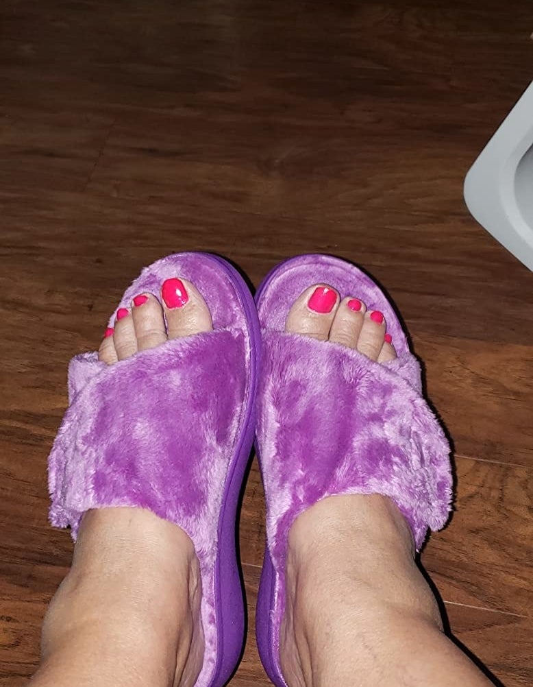 Reviewer wearing purple open-toe fuzzy slippers
