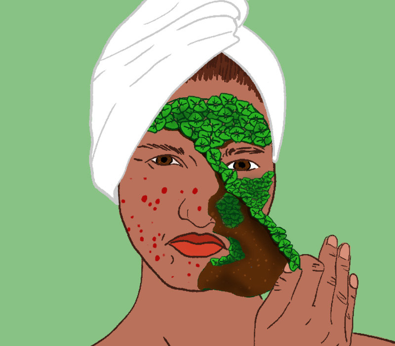 A woman with a towel on her head peeling a cosmetic face mask made of sprouting plants from her face. her face still has pimples.