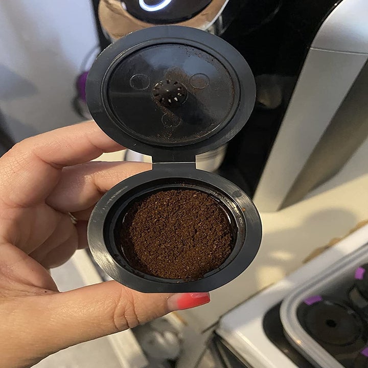 Reviewer holding K cup full of coffee grounds