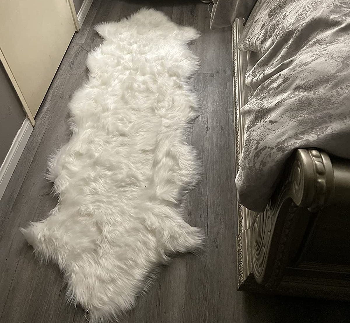 Reviewer image of faux fur rug next to the bed