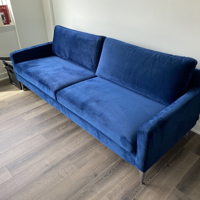 a reviewer photo of the blue velvet couch