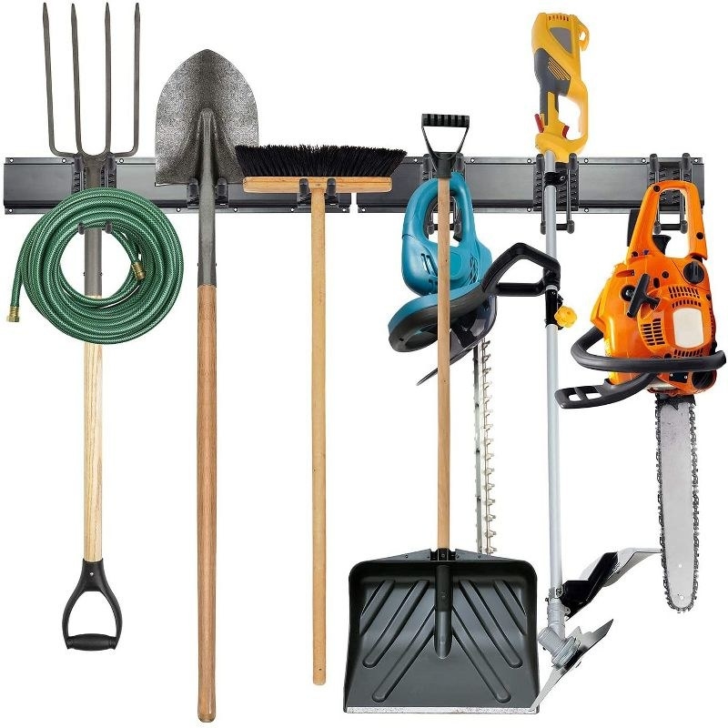 an eight piece garage organizer holding a pitchfork, shovel, chainsaw, and other items