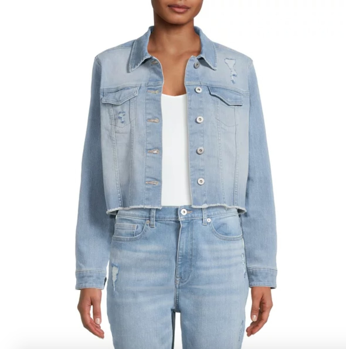 A model in a light blue denim jacket and jeans and a white tee
