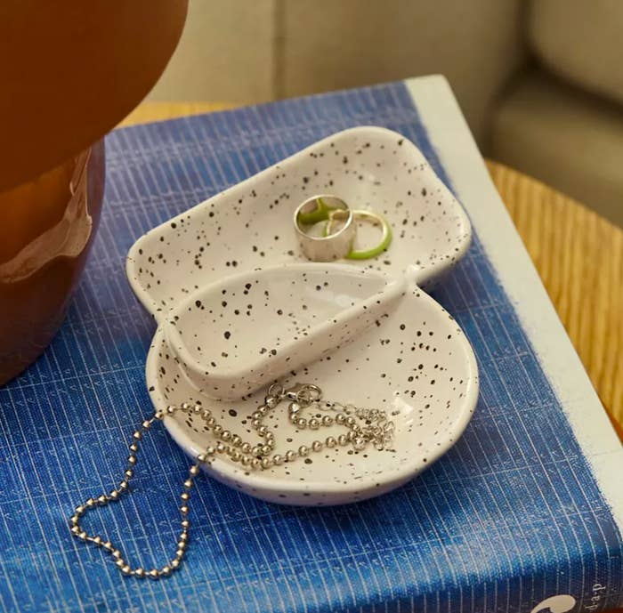 The catchall dish on a book with trinkets inside