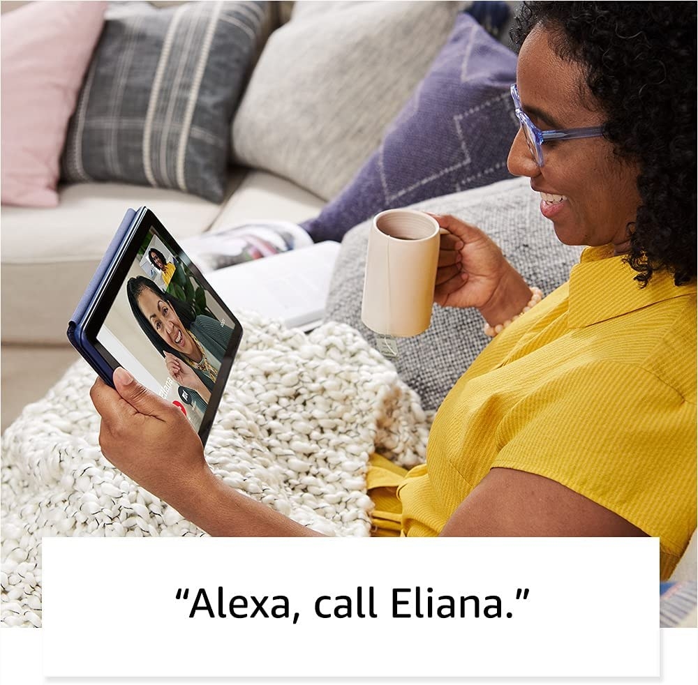 Someone video calling a friend with the table while sitting on their couch under blanket.