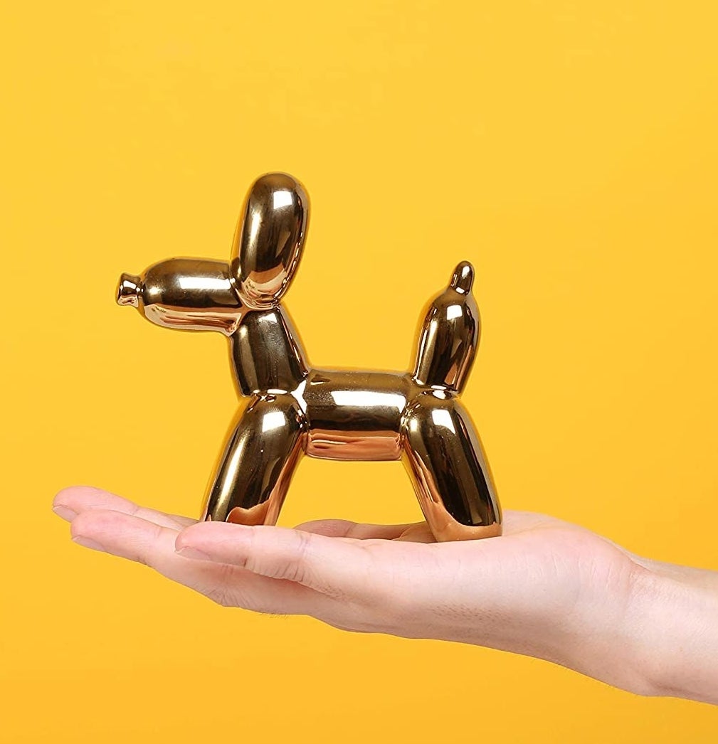 A person holding the dog balloon sculpture