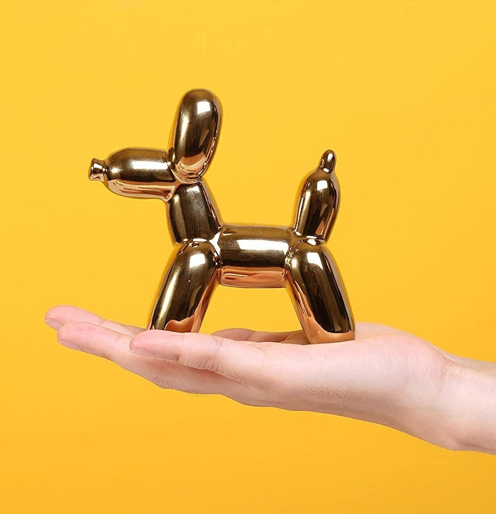 A person holding the dog balloon sculpture