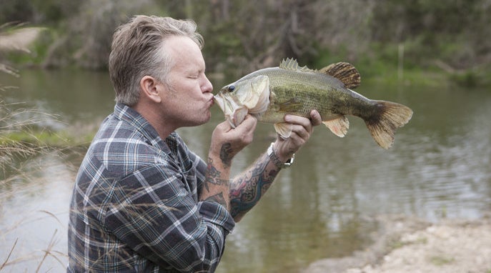a man kissing a fish