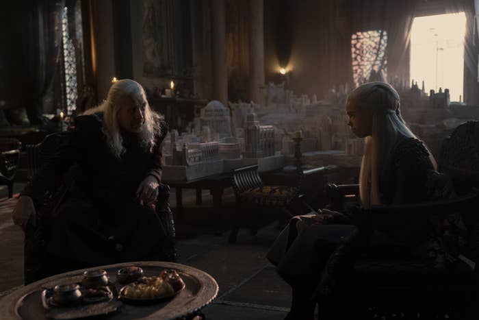 Viserys sits opposite Rhaenyra in front of his model of Old Valyria