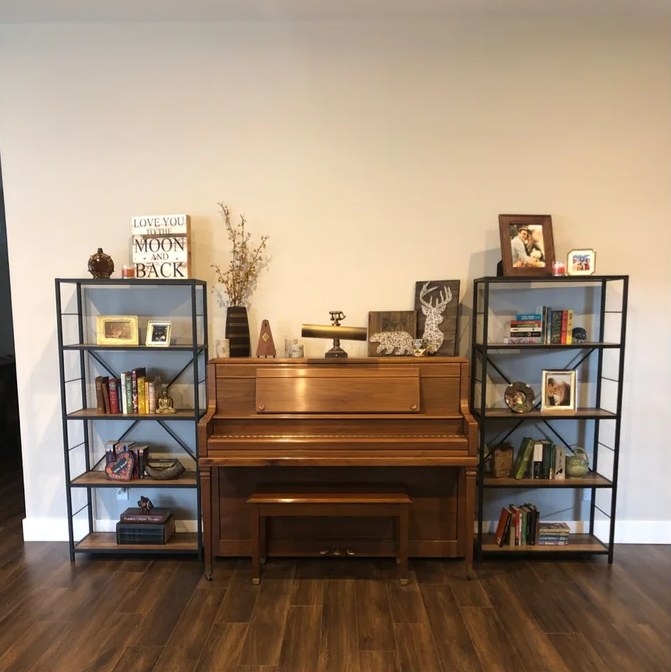 A reviewer&#x27;s image of two rustic oak metal bookcases