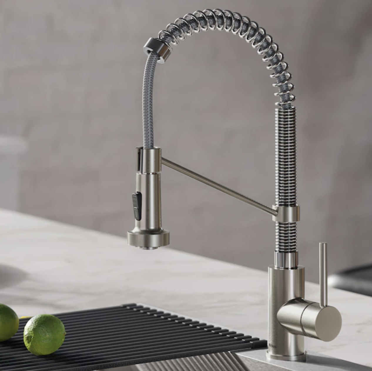 stainless steel/chrome pull-down handle kitchen faucet above sink with fold-over drying rack and limes