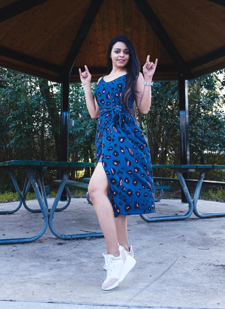 reviewer wearing the blue leopard dress with white sneakers