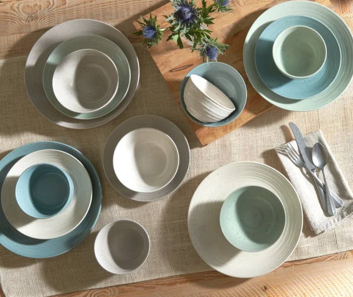 16-piece blue, white, and mint green plates and bowls set on wooden table