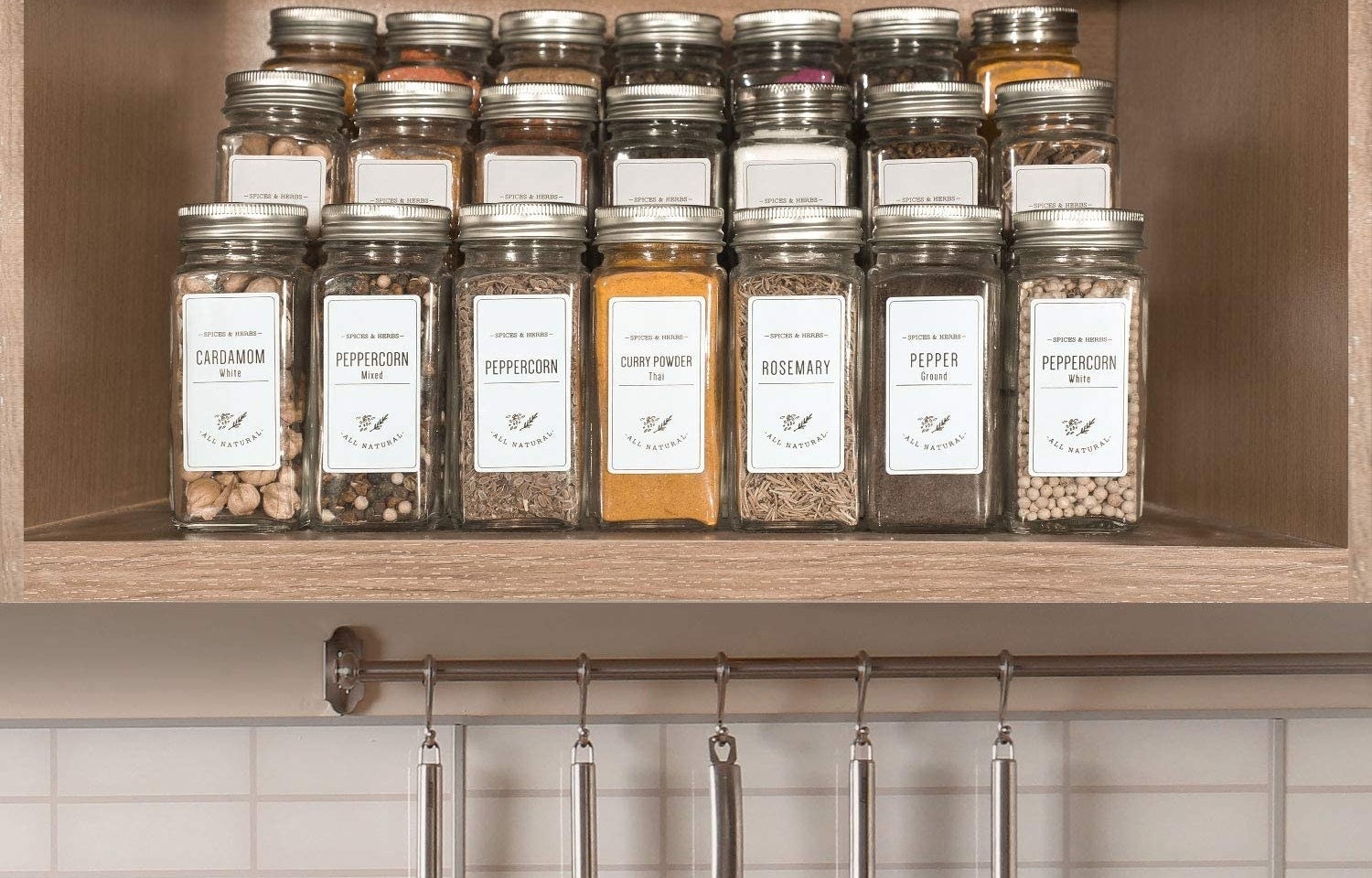 the 24-piece glass spice jar set with spice labels neatly organized in kitchen cabinet