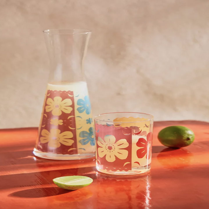 floral-printed glass carafe with matching glass on burgundy table