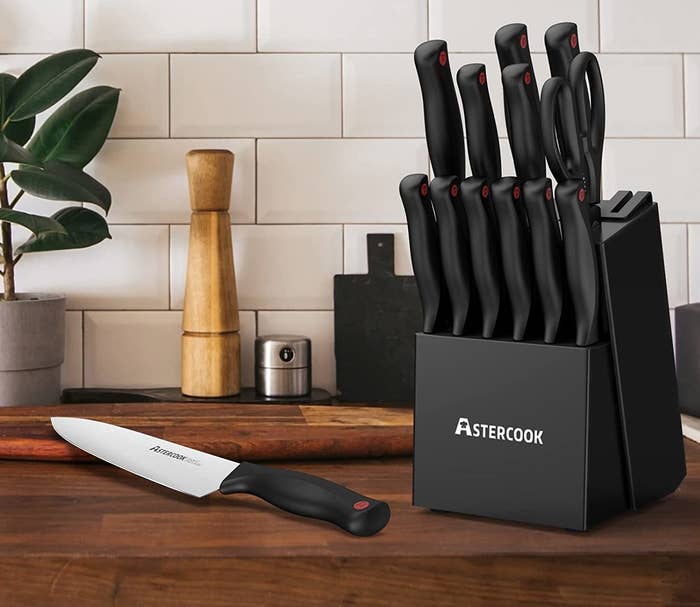 the 14-piece knife set with sharpening block and scissors on wood kitchen counter