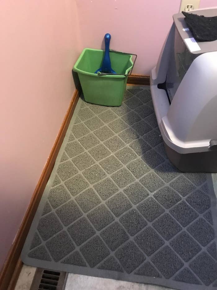 a reviewer photo of the grey mat in front of a covered litter box