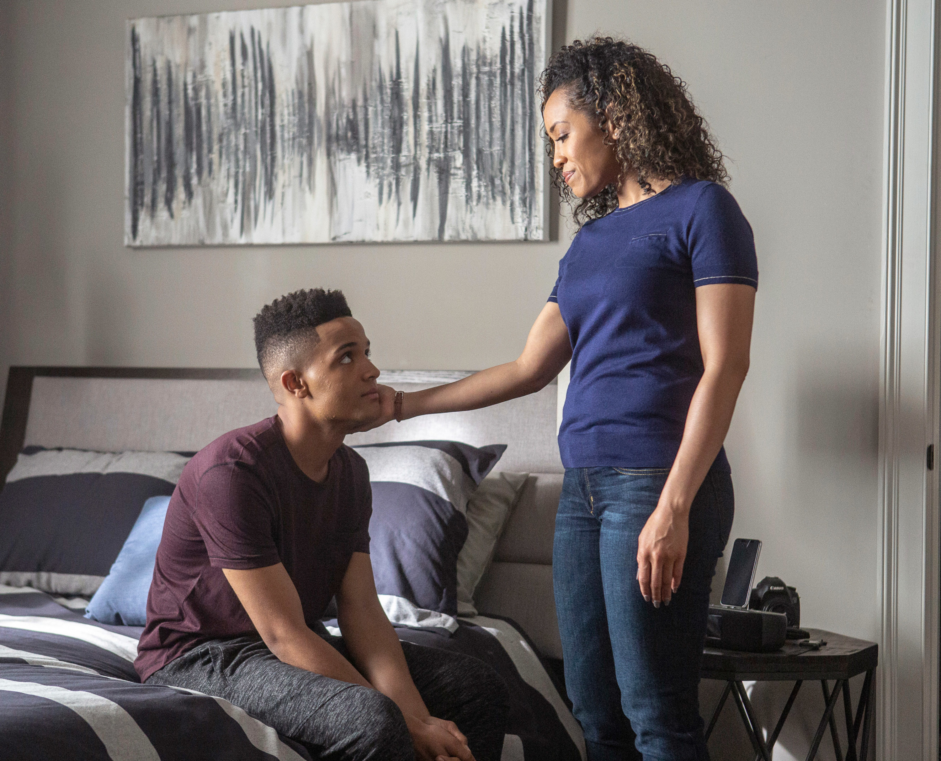 Queen Sugar scene with Nicholas sitting on a bed while another actor stands in front of him while putting her hand on his cheek