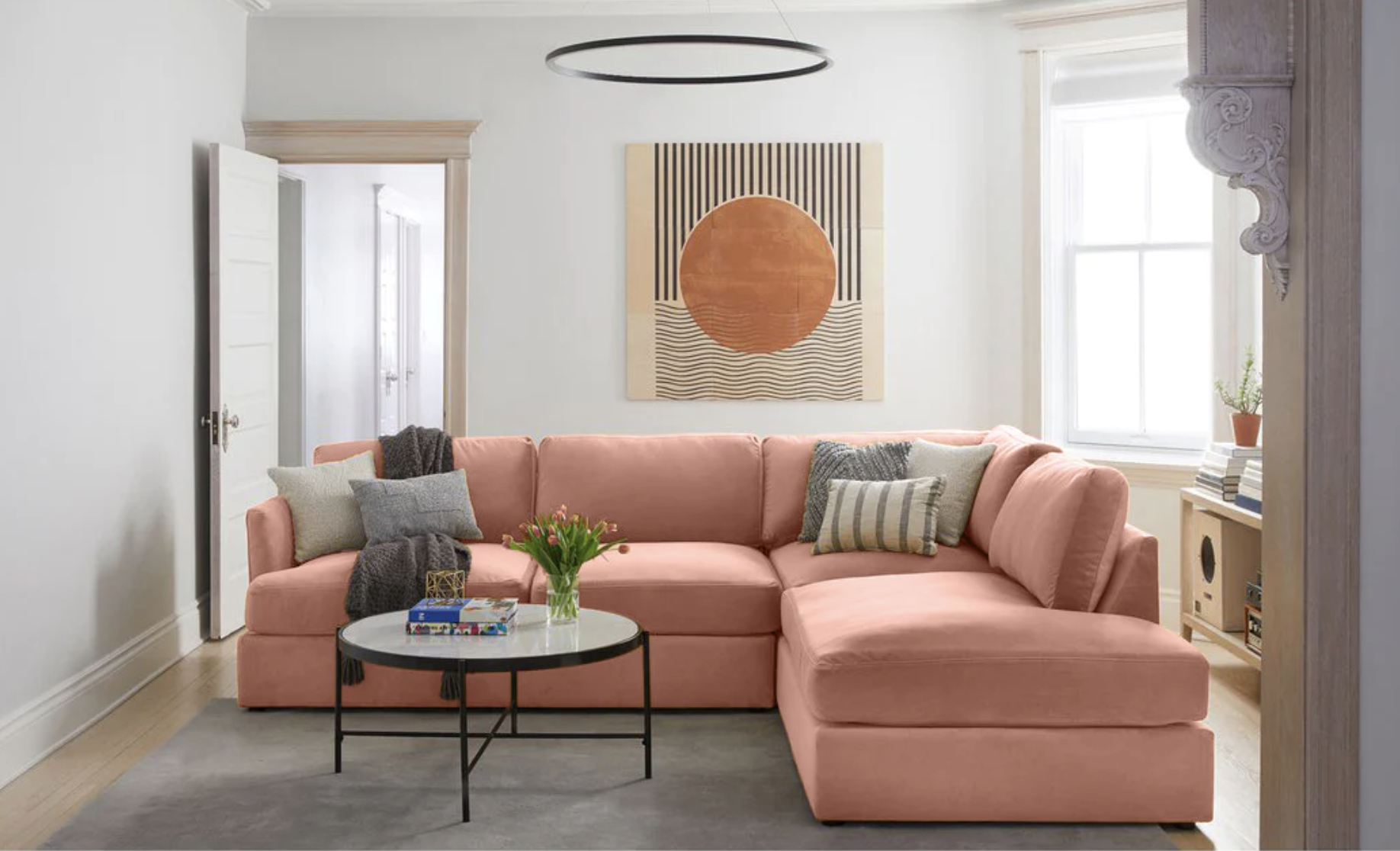 A pink velvet sectional is shown in a living room