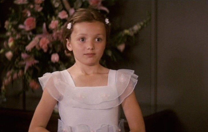 Peyton in a sleeveless dress with bows and frills and hair clips