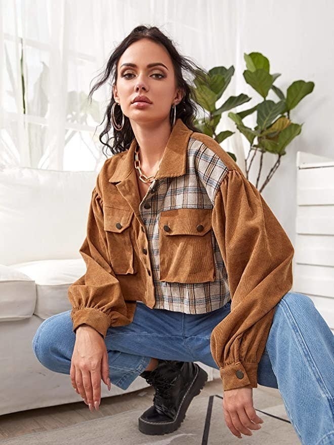 a person crouching down while wearing the jacket with jeans and boots